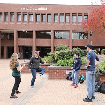 Students play hackey sack outside the Billington Library on the main 赌钱app可以微信提现 campus.